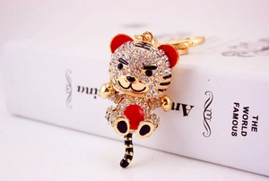 Detailed close-up of golden metal tiger keychain with sparkling rhinestone inlay