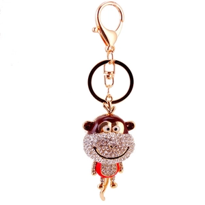 Cute cartoon monkey keychain with rhinestones and gold plating on white background