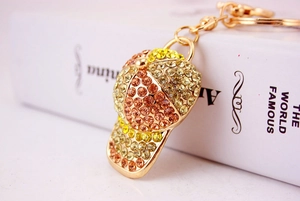 Macro shot of baseball cap keychain with sparkling rhinestones and golden metal ring