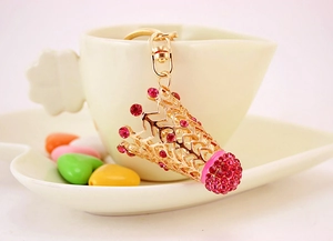 Gros plan d'un porte-clés couronne dorée avec strass roses sur une tasse en céramique
