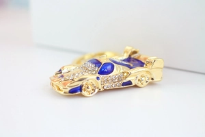 Détail du porte-clés voiture de course doré avec strass brillants et émail bleu foncé