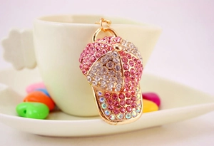 Detail of pink and white rhinestones encrusted baseball cap keychain on white ceramic