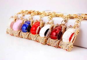 Detail showing colorful oil-drop car keychains with sparkling rhinestones and golden clasps