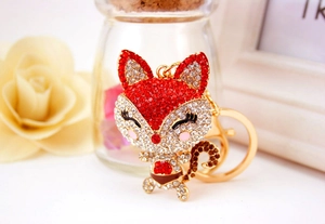 Macro shot of a cartoon fox keychain with sparkling crystals and a gold lobster clasp