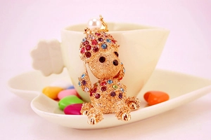 Detailed view of golden poodle keychain with colorful rhinestones and a white faux pearl