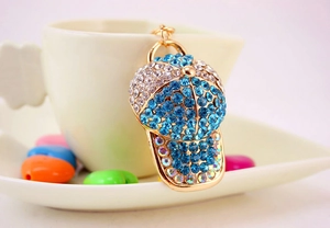 Detail of creative baseball cap keychain with blue and clear rhinestones on gold alloy