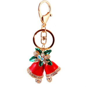 Porte-clés cloche de Noël rouge avec feuilles vertes et nœud en cristal sur fond blanc