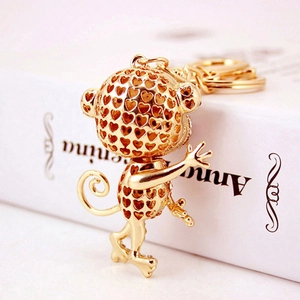 Creative golden monkey keychain with hollow heart design and rhinestone accents