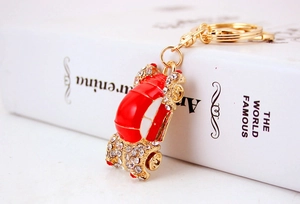 Detailed macro view of red enamel car keychain with sparkling crystals and golden metal ring