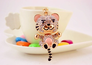 Close-up of cute cartoon tiger keychain with sparkling rhinestones and pink enamel finish
