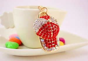 Close-up of red and white rhinestone baseball cap keychain hanging on a white coffee cup