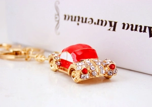 Close-up of vintage mini car keychain with red enamel and sparkling white rhinestones