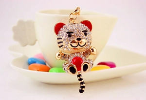 Close-up of cute cartoon tiger keychain featuring sparkling crystals and enamel details
