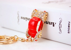 Detail of red enamel car keychain with sparkling rhinestones and golden metal hardware