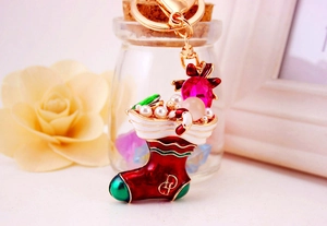 Macro shot of Christmas stocking keychain with pink rhinestones and enamel finish