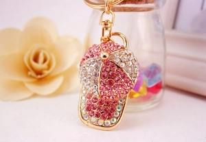 Macro shot of pink rhinestone baseball cap keychain with golden alloy finish