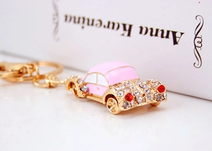Detail of pink vintage car keychain with white crystals and gold metal lobster clasp