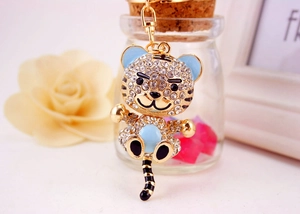 Detail of cartoon tiger keychain with gold plating, sparkling rhinestones and blue enamel