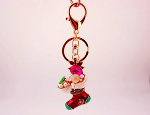 Detail of red enamel Christmas boot keychain with pink rhinestone and pearl accents