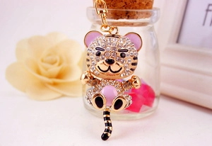 Macro detail of cartoon tiger keychain with sparkling rhinestones and pink enamel