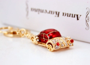 Close-up of vintage car keychain with red enamel and shimmering white rhinestones
