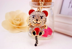 Close-up of golden zodiac tiger keychain with red gem and sparkling crystal rhinestones