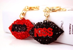 Macro detail of red and black rhinestone KISS lip keychains with gold polished hardware