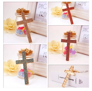 Detail showing cross rhinestone keychains in multiple colors with polished metal key rings