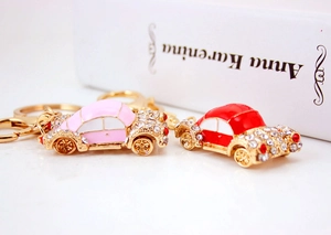Detail of pink and red cartoon vintage car keychains with sparkling crystals and gold plating