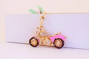 Pink rhinestone motorcycle keychain with gold plating and enamel details on white gift box