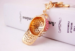 Macro shot of gold baseball cap keychain with pink and clear rhinestones and lobster clasp