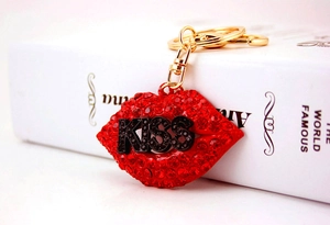 Macro view of sparkling red rhinestone lips keychain with gold lobster clasp and KISS logo