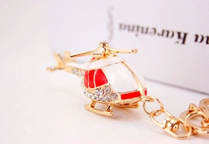 Detailed macro view of the gold-plated helicopter keychain with sparkling white rhinestones