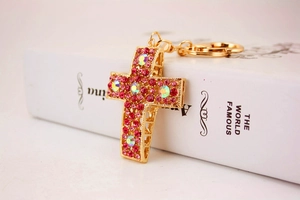 Détail du porte-clés croix avec strass roses et colorés AB sur une structure en alliage doré