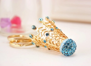 Détail du porte-clés badminton doré avec strass bleu ciel et détails en maille métallique
