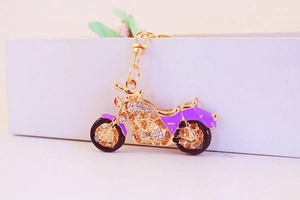 Detail view of motorcycle keychain with purple enamel and glittering crystal rhinestones
