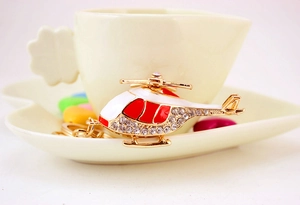 Close-up of golden helicopter keychain with sparkling rhinestones and enamel details