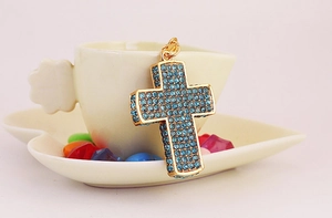 Nahaufnahme des goldenen Kreuz-Schlüsselanhängers mit blauen Strasssteinen
