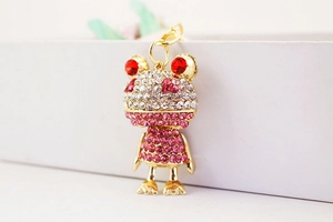 Detailaufnahme des goldenen Frosch-Schlüsselanhängers mit rosa und roten Strasssteinen