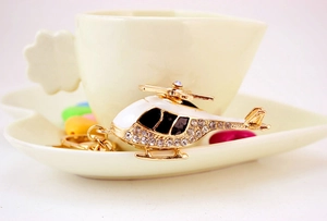 Detail of gold-plated helicopter keychain with sparkling rhinestones on ceramic