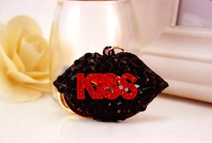 Macro shot of stylish black rhinestone lip keychain with red KISS crystal lettering