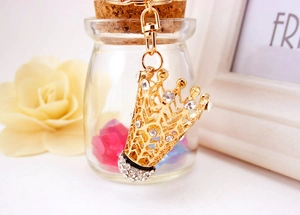 Gros plan d'un porte-clés couronne dorée orné de strass brillants et mousqueton