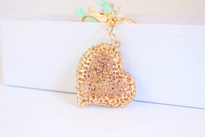 Detailed close-up of golden heart keychain featuring a unique hollow coral texture