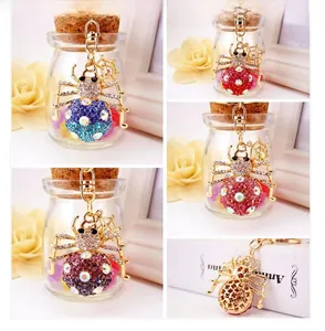 Detail of crystal rhinestone spider keychains showing back hollow pattern and colors