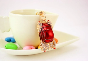 Detailed close-up of a red car keychain with white rhinestones on a ceramic cup