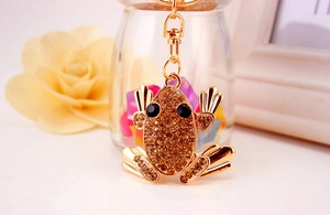 Detail view of champagne gold frog keychain with sparkling crystals and lobster clasp
