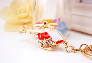 Close-up of golden helicopter keychain with sparkling rhinestones and enamel finish