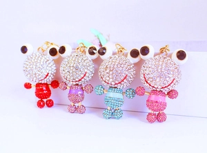 Quatre porte-clés grenouille colorés en rouge, violet, bleu et rose avec des strass brillants