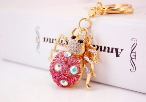 Close-up of pink rhinestone ladybug keychain with golden base and AB crystals