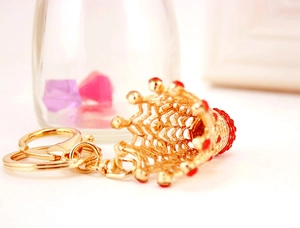 Détail du porte-clés couronne dorée serti de strass rouges et crochet en métal